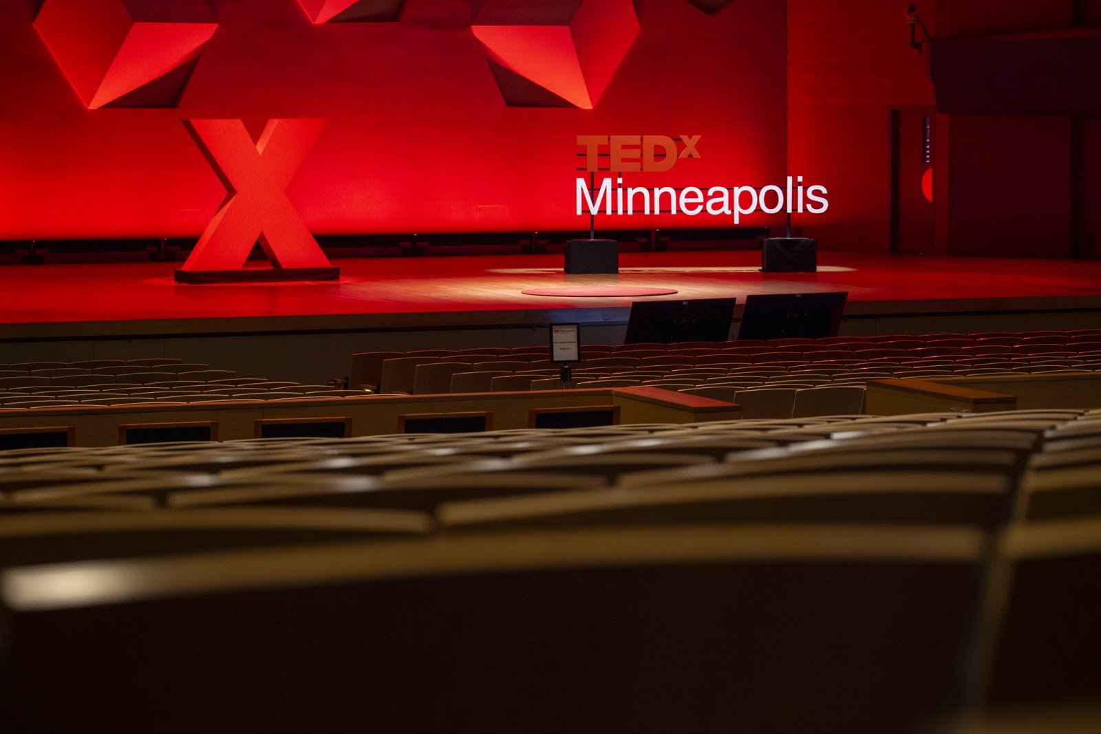 The TEDxMinneapolis stage lit in red before the program