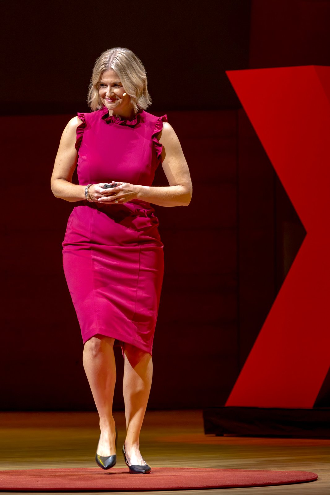 Katherine standing on the red dot beside the TEDx X