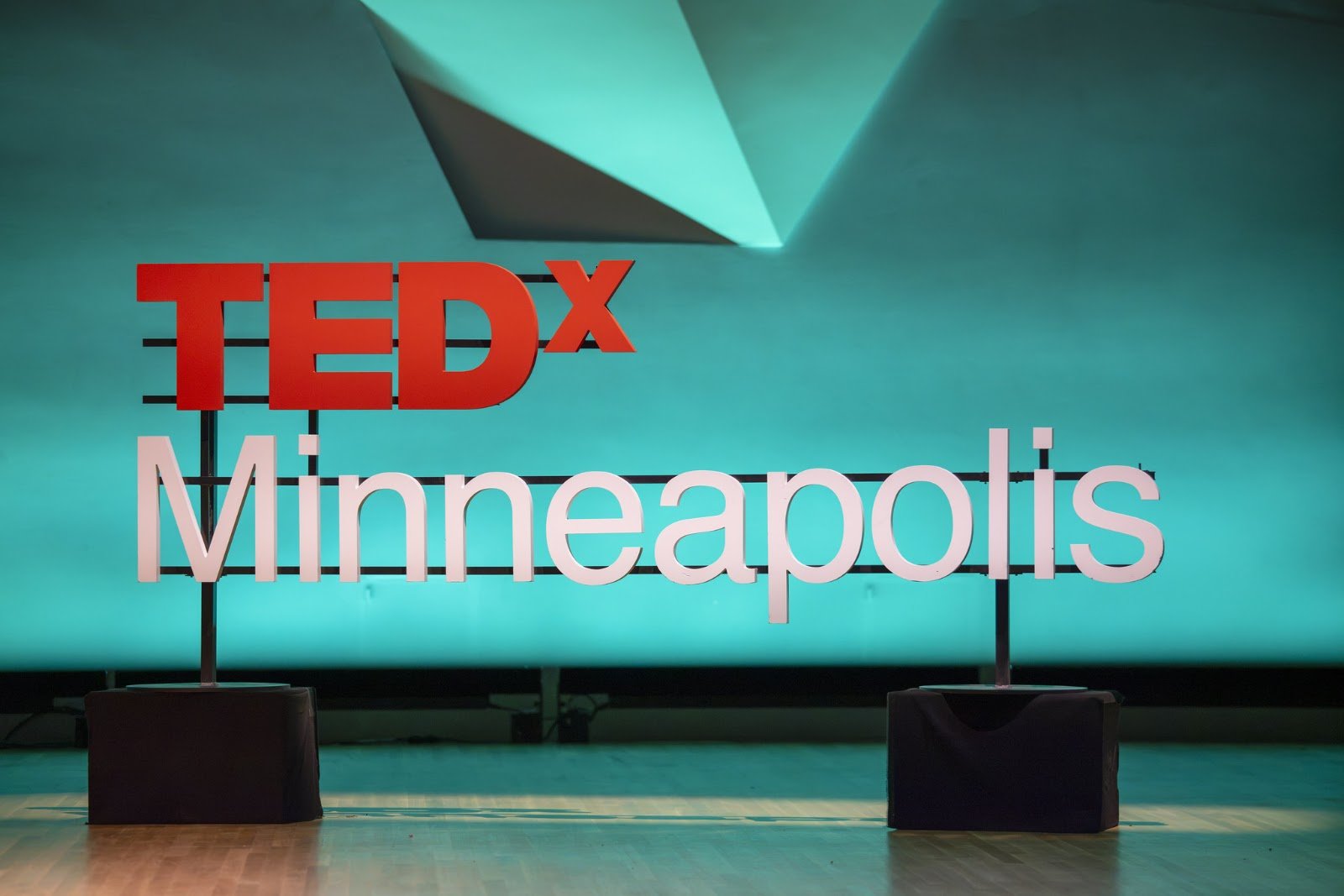 The TEDxMinneapolis stage lit in teal