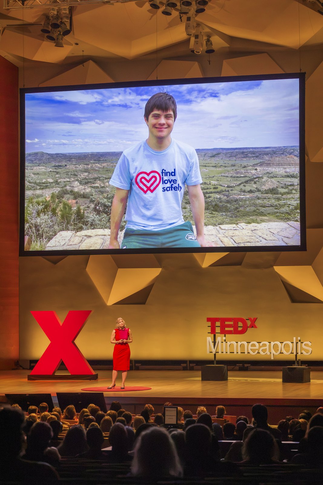 A photo of Katherine’s son Nicolas in a Find Love Safely shirt on the TEDx screen