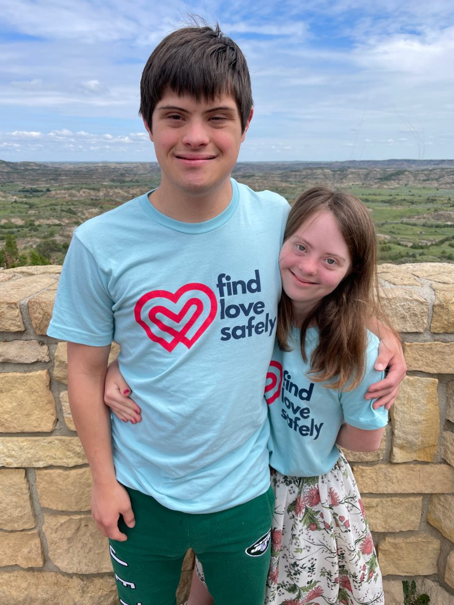 Nicolas and Stella in matching Find Love Safely shirts at a badlands overlook