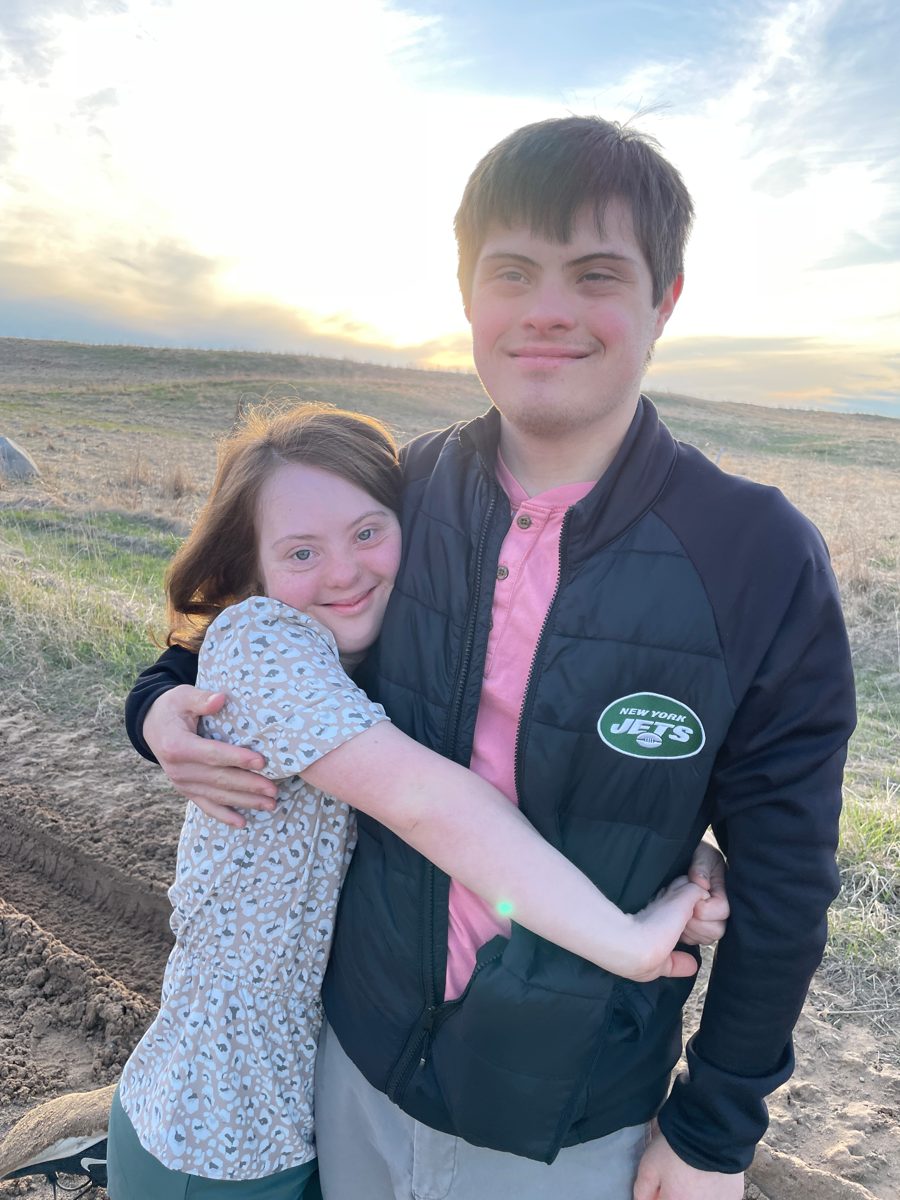 Nicolas and Stella hugging in a field at sunset